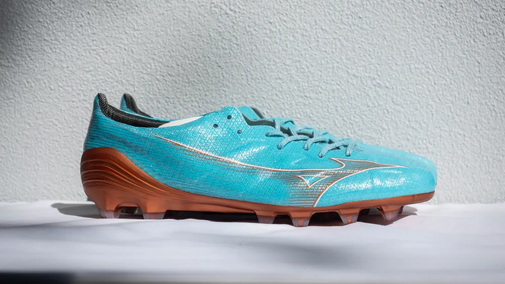 Side profile of a Mizuno Alpha Japan Made in Japan boot in Azure Blue with a copper soleplate